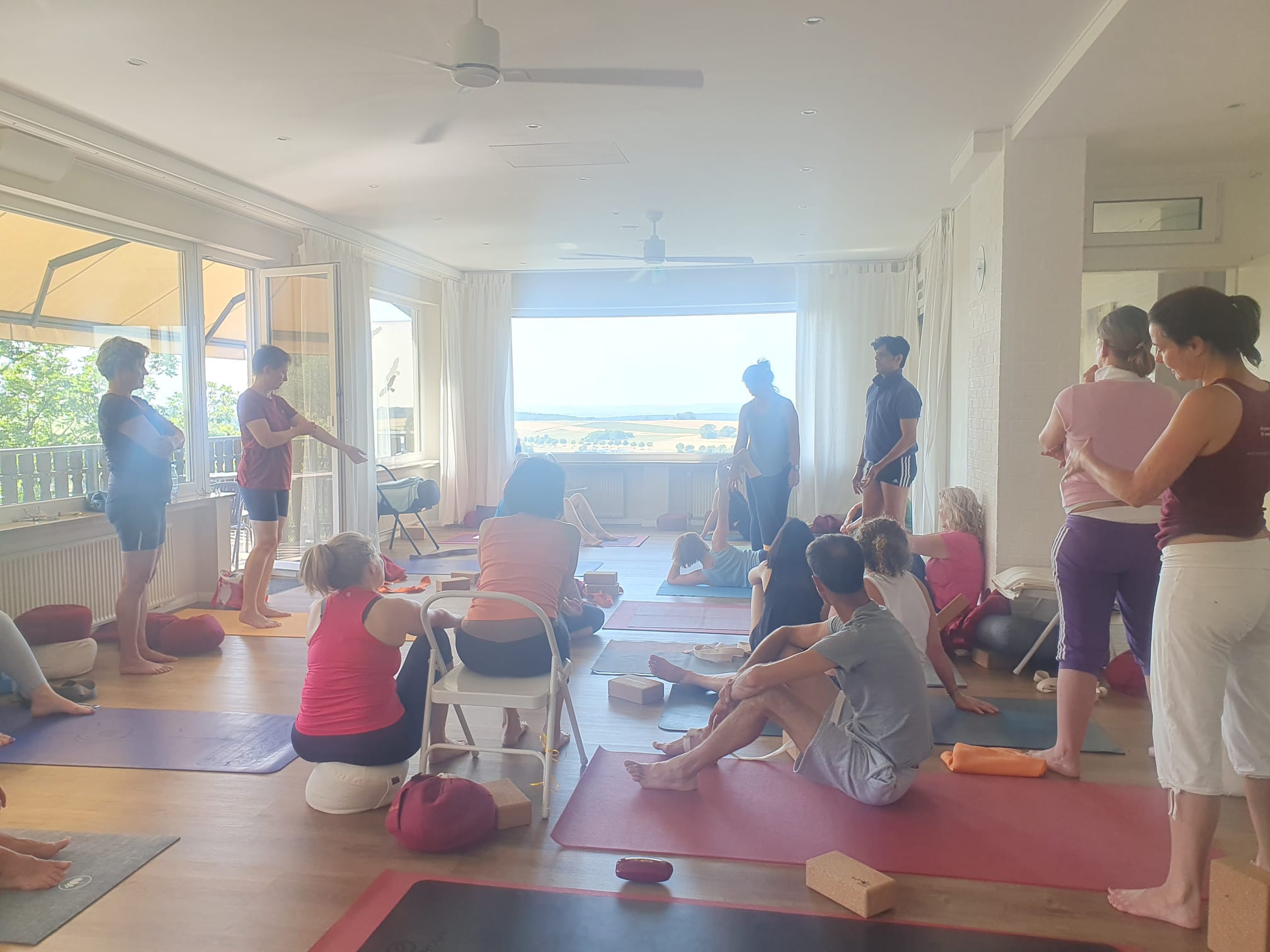 Teilnehmende beobachten eine Unterrichtssituation beim Yoga-Retreat in Deutschland